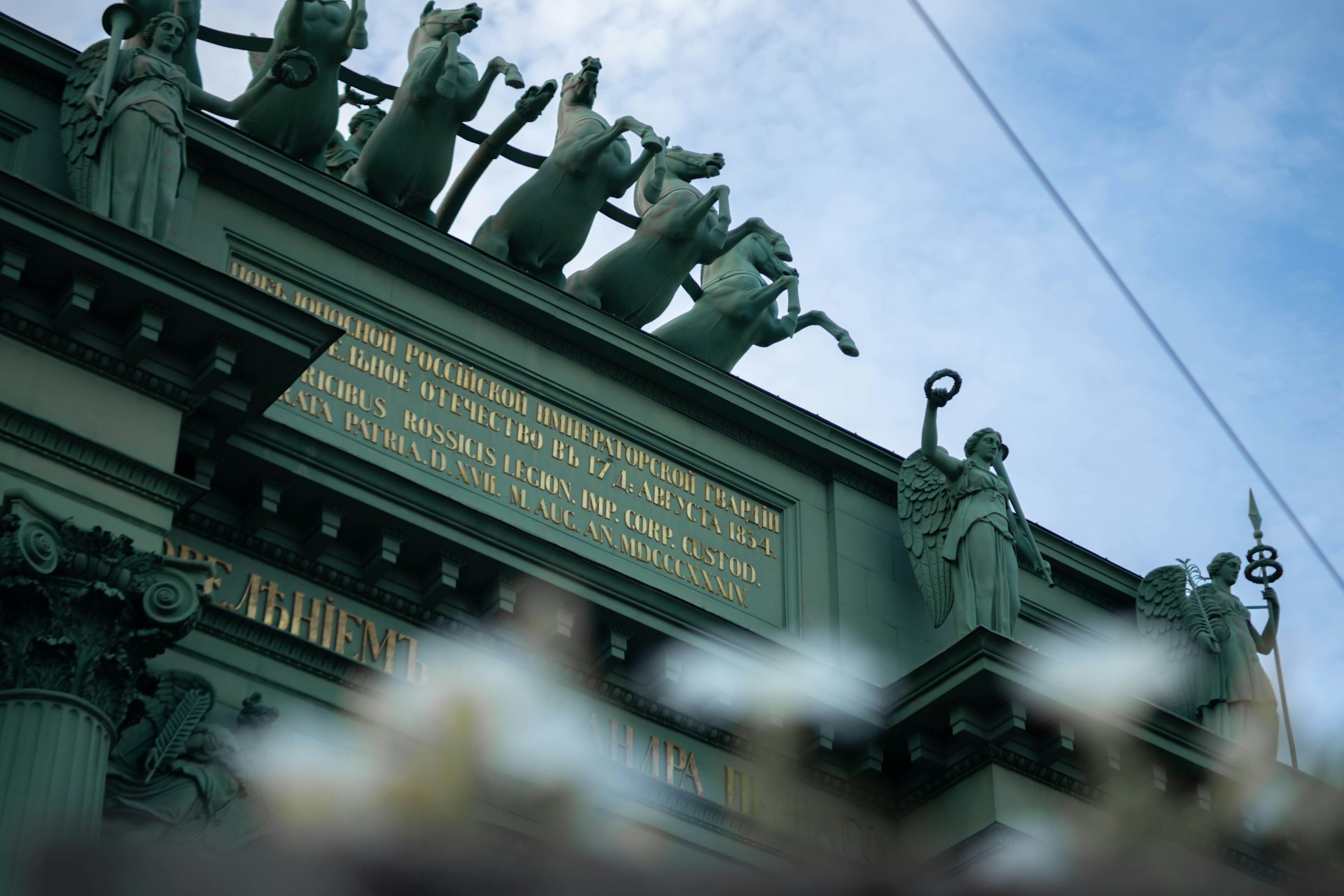 Horses and statues adorn a grand architectural structure.